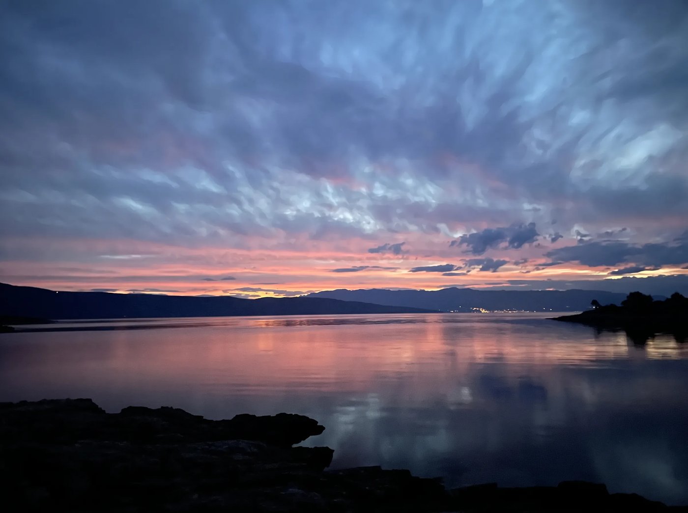 Sunset over the calm Adriatic sea and the coastline of Hvar.