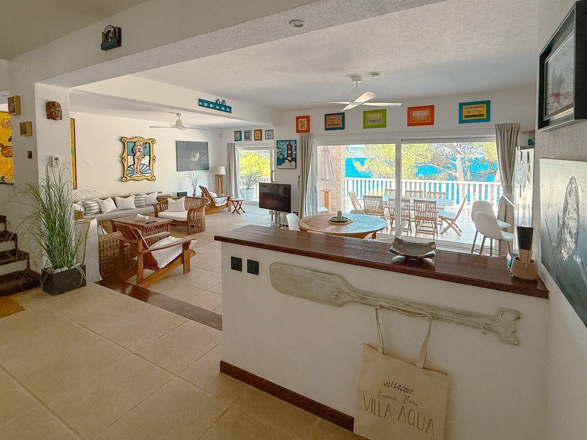Open-plan living room with artwork and rattan furniture